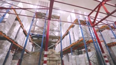 Kamera fabrika deposundan geçiyor. Modern depo, endüstriyel iç mekan. İçinde insan olmayan modern bir depo..