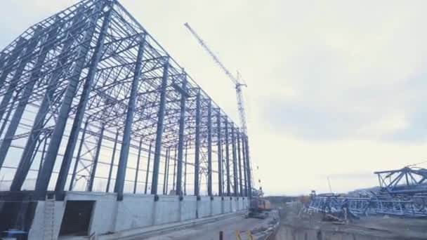 Bau einer großen Lagerhalle für eine Fabrik. Industrieller Außenbereich. Großes Stahlkonstruktionsgebäude. Metallrahmen eines Industriegebäudes. Bau eines Industriegebäudes. — Stockvideo