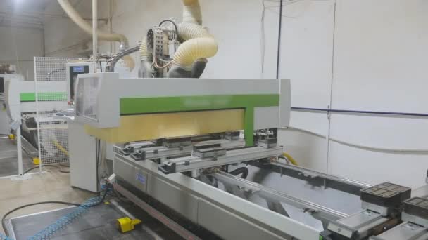 Automatiserad cnc maskin i en möbelfabrik. Industriell inredning. CNC-maskin bearbetar träskiva. Fräsning av en träskiva. — Stockvideo