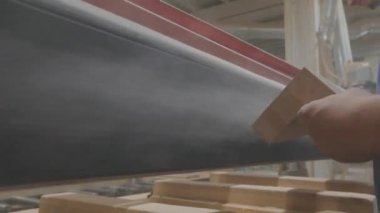 Sanding a wooden piece. The process of polishing wood products. Furniture factory