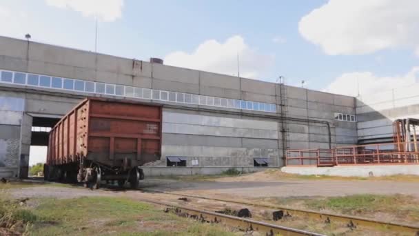 Un vagón rojo sale de la tienda de la fábrica. Paseos en vagón de mercancías por el territorio de la fábrica — Vídeos de Stock