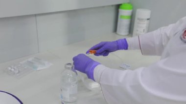 Bir sağlık çalışanı serum hazırlıyor. Hemşire bir serumla çalışıyor..