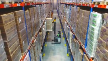 Depodaki modern ekipmanların işi. Kutularla dolu bir depoda modern forklift.