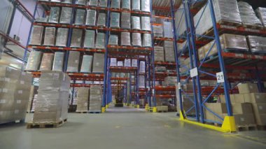 Forklift depodan geçiyor. Hidrolik asansör modern bir depoda hareket ediyor.