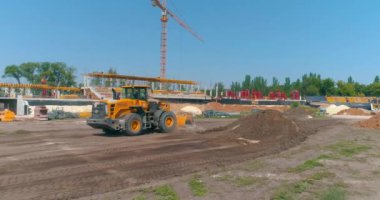 Havadan inşaat alanındaki modern traktör. Büyük sarı traktör. Profesyonel inşaat malzemeleri. İnşaat alanında çalışma süreci