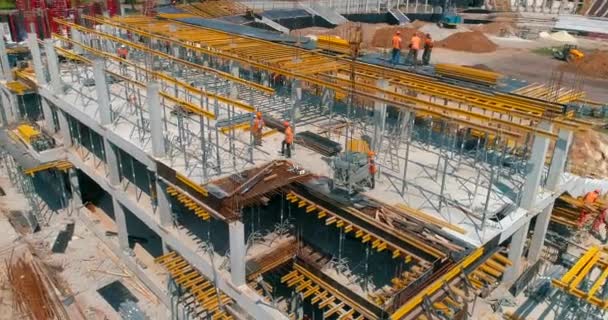 Flygfoto av armerad betongkonstruktion. Byggare gör formarbete på byggarbetsplatsen för en ny stadion. Byggande av en modern fotbollsstadion. — Stockvideo