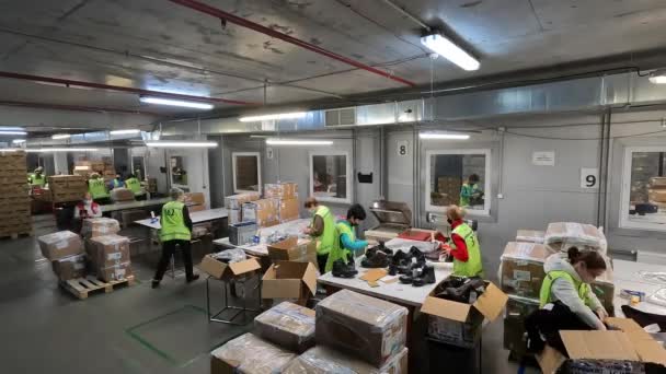 Προετοιμασία εμπορευμάτων για αποστολή. Κέντρο διαχείρισης. Συσκευάζοντας εμπορεύματα σε κουτιά. Γυναίκες συσκευάζοντας προϊόντα σε κουτιά για τη ναυτιλία — Αρχείο Βίντεο