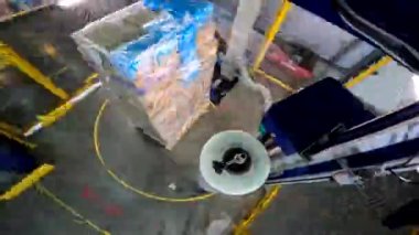 Paket germe makinesi zaman ayarlı. Palet ambalaj makinesi. Kutuları daire şeklinde plastik bir filme sarmak için bir makine. Plastik filmde kutular paketleniyor.