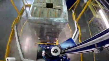 Paket germe makinesi zaman ayarlı. Palet ambalaj makinesi. Kutuları daire şeklinde plastik bir filme sarmak için bir makine. Plastik filmde kutular paketleniyor.