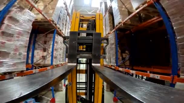 The load lifter rides on the warehouse pov. Forklift fork close-up. Modern forklift in a large warehouse — Wideo stockowe