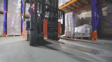 Forklift hareket halinde, yakın plan. Depodan geçen bir forkliftin yakın çekimi. Forklift tekerlekleri yakın çekim