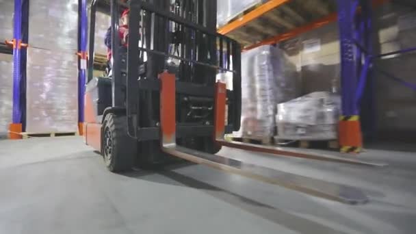 Forklift σε κίνηση από κοντά. Κοντινό πλάνο ενός κλαρκ που κινείται μέσα από μια αποθήκη. Τροχοί περονοφόρου ανυψωτικού οχήματος — Αρχείο Βίντεο