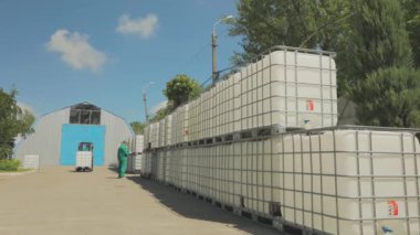 Forklift konteynırı fabrikada taşıyor. Forklift sıvıyla birlikte taşıyıcıyı kaldırır. Hava forklift işlemini aç