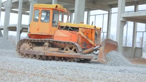 Bulldozern jämnar ut jordlagret. Bulldozer jobbar på en byggarbetsplats. Gul bulldozer på byggarbetsplatsen. Bulldozer vid byggarbetsplatsen. Tung byggutrustning — Stockvideo