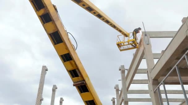 A welder on a crane performs welding work. Workflow at a construction site. Welder performs high-altitude work — Vídeo de Stock