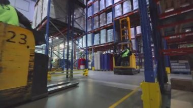 Fabrikanın deposunda özel ekipman var. Depoyu turlayan bir sürü forklift var. Modern yükleyiciler büyük bir depoda.