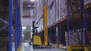 Depo işi. Büyük bir depoda iş akışı. Fabrikanın deposunda özel ekipman var. Modern yükleyiciler büyük bir depoda..