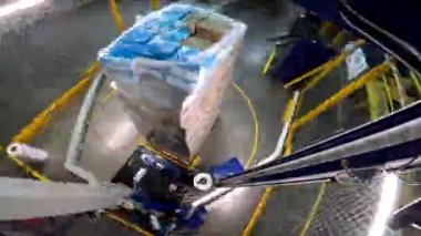 Paket germe makinesi zaman ayarlı. Palet ambalaj makinesi. Kutuları daire şeklinde plastik bir filme sarmak için bir makine. Plastik filmde kutular paketleniyor.