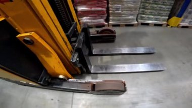 Forklift depodan geçiyor. Depoda özel araçlar dolaşıyor.