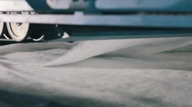 Sentetik kışlık üretim fabrikası. Syntepon üretim süreci. Baston olmayan malzemelerin üretimi yakın plan..