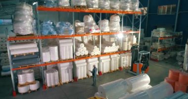 Dokumasız fabrikasındaki depo. Kumaşsız kumaş deposuna uçuş. Sentetik kış sarmalı büyük modern bir depo.