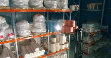 Dokumasız fabrikasındaki depo. Kumaşsız kumaş deposuna uçuş. Sentetik kış sarmalı büyük modern bir depo.