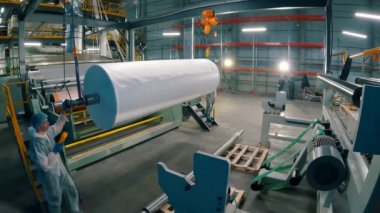 Agrofiber bir rulo üzerinde yara var. Agrofiber üretim. Endüstriyel iç mekan. Otomatik taşıma hattı