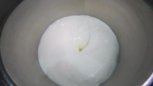 Mleko obraca się w dużej beczce. Przygotowanie lodów. Mieszanie mleka w fabryce. — Wideo stockowe
