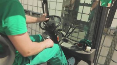 Forklift sürücüsü kolları hareket ettiriyor. Bir işçi forklift kullanıyor. Forklift denetim süreci