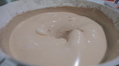 Waffle kabı pişirmek için hamur hazırlığı. Yiyecek üretimi. Waffle için hamur topluyorum. Fabrikada para kazanma süreci.