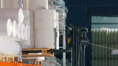 Forklift malları depodaki raflara koyuyor. Depo işi. Agrofiber ambarın rafına konmuş..