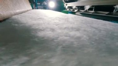 Baston olmayan malzemelerin üretimi yakın plan. Sentetik kışlık üretim fabrikası. Syntepon üretim süreci.