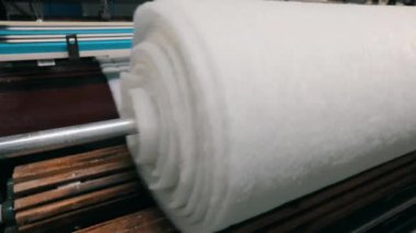 Baston olmayan malzemelerin üretimi yakın plan. Sentetik kışlık üretim fabrikası. Syntepon üretim süreci.