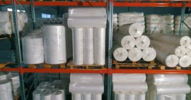 Dokumasız fabrikasındaki depo. Kumaşsız kumaş deposuna uçuş. Sentetik kış sarmalı büyük modern bir depo..