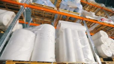 Dokumasız rulolarla dolu bir depo. Dokumasız kumaş fabrikasında büyük bir depo..