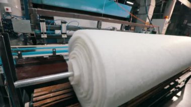 Baston olmayan malzemelerin üretimi yakın plan. Sentetik kışlık üretim fabrikası. Syntepon üretim süreci.