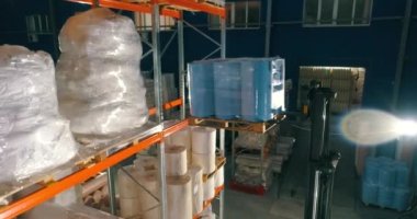Dokumasız fabrikasındaki depo. Kumaşsız kumaş deposuna uçuş. Sentetik kış sarmalı büyük modern bir depo..