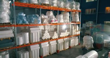 Dokumasız fabrikasındaki depo. Kumaşsız kumaş deposuna uçuş. Sentetik kış sarmalı büyük modern bir depo..