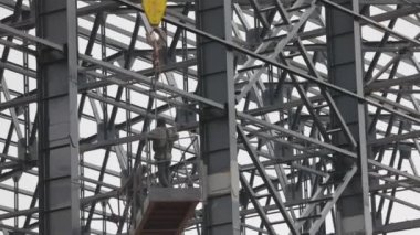 İşçiler metal yapılar boyuyor. İnşaat işi. Endüstriyel dış görünüş. İnşaatçılar binanın metal yapısını un ufak ediyorlar..