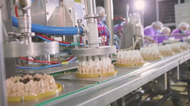 Otomatik dondurma üretimi. Dondurmalı pasta yapmak için otomatik taşıyıcı. Dondurma tüplerden çıkarıldı..