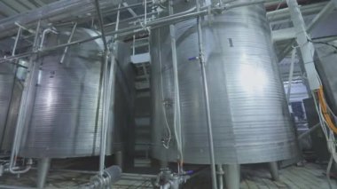 Gıda endüstrisindeki büyük konteynırlar. Dondurma endüstrisindeki parlak metal kaplar. Endüstriyel iç mekan. Gıda üretimi.