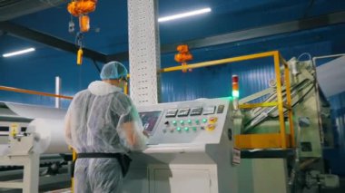 Modern bir fabrikada işçiler. İnsanlar modern dokumasız bir fabrikanın atölyesinde çalışırlar. Fabrikada çalışma süreci. endüstriyel iç.