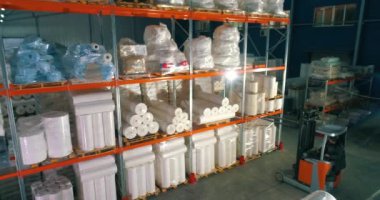 Dokumasız fabrikasındaki depo. Kumaşsız kumaş deposuna uçuş. Sentetik kış sarmalı büyük modern bir depo..
