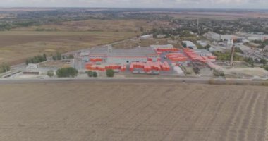 Modern bir fabrikanın endüstriyel dış mekanı. Modern fabrika manzaralı, turuncu renkli yeni bir fabrikanın etrafında uçuyor..