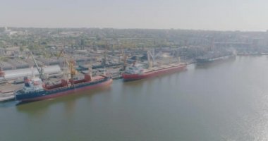 Limanda kuru kargo gemisi var. İskele vinci kargoyu kuru bir kargo gemisine yüklüyor. Limanın üzerinden kargo gemileriyle uçun..