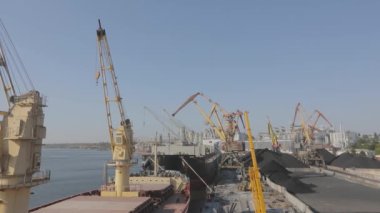 Malzemeleri gemiye yüklemek, kargo gemisine limanda vinç yüklemek. Limanda kargo gemileri yüklüyor..