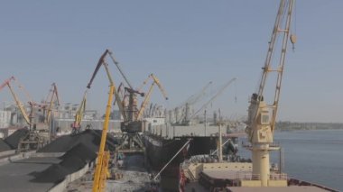 Gemi vincinden kömür boşaltıyorum. Gemi limandaki vinçlerle boşaltıldı. Ukrayna limanında gemiler.