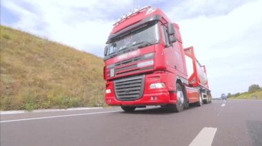 Kırmızı kamyon otoyol boyunca gidiyor. Bir grup kamyon otoyol boyunca gidiyor. Modern kamyonlar tanklarda sıvı kargo taşıyorlar.