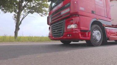 Kırmızı kamyon otoyol boyunca gidiyor. Bir grup kamyon otoyol boyunca gidiyor. Modern kamyonlar tanklarda sıvı kargo taşıyorlar.