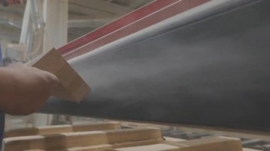 Sanding a wooden piece. The process of polishing wood products. Furniture factory.